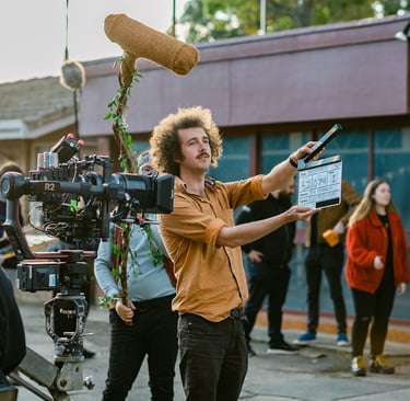 Director Tim Carlier stands with a clapper board in front of a camera on his shor film set 'Parco'