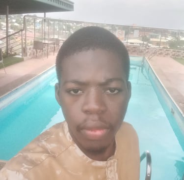 a young man standing in front of a swimming pool