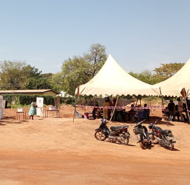 a group of eligible Ghana's standing around a tent casting their vot