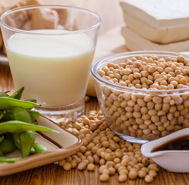 a table with a glass of soy milk and a bowl of soy beans