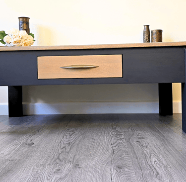 Image of a painted coffee table with a natural wood top and drawer