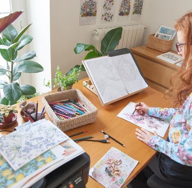 a woman sitting at a desk drawing