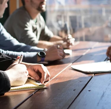 quatre hommes qui parlent autour d'une table