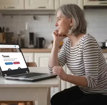 Une quinquagénaire regardant son ordinateur sur la table de sa cuisine