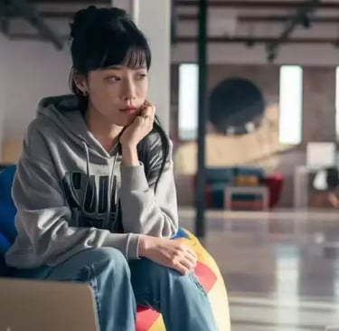 Une jeune asiatique songeuse dans un co working