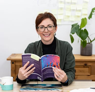 a woman is smiling and holding a book