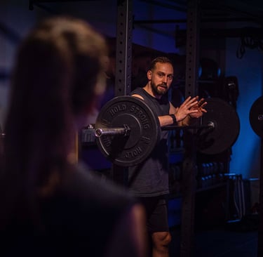 a man is holding a barbell in a gym