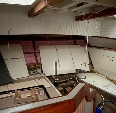 Aft state room with white panelling, the rudder post in the centre and storage on the side