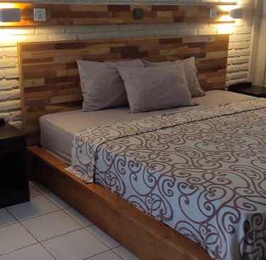 a bed with a bed and a lamp made in singaraja by DharmaJaya Furniture
