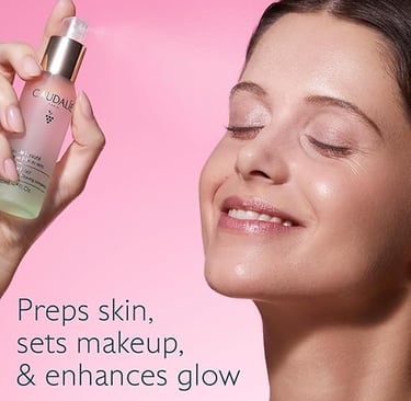 Elegant woman spritzing Caudalie Beauty Elixir onto her face with eyes closed, enjoying a refreshing
