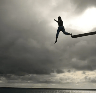A very brave person jumping off a high diving board