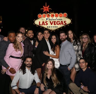 Group photo in front of the Welcome to Las Vegas sign during a VIP club crawl experience.