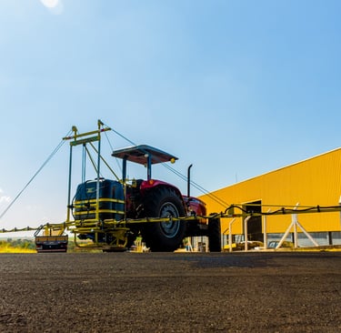 Pulverizador agrícola JLS Nadja 0.6k com a fábrica da JLS ao fundo