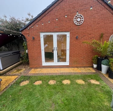 Side aspect of converted garage with French doors