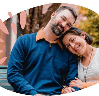 a man and woman leaning on each other smiling
