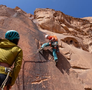 Female climbers lead up an imposing desert headwall in Wadi Rum, Jordan