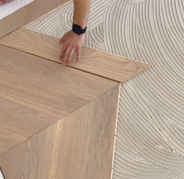 Pose de parquet collé sur sous-couche encollée avec alignement soigné des lames
