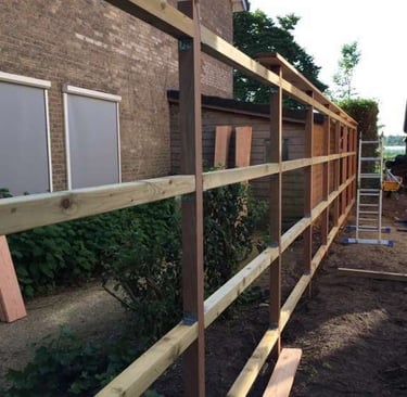 Structure en bois pour clôture de jardin en construction – montage des traverses avant fixation des