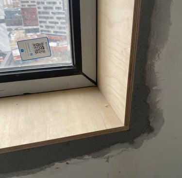 Habillage intérieur de baie vitrée avec encadrement en bois brut sur chantier