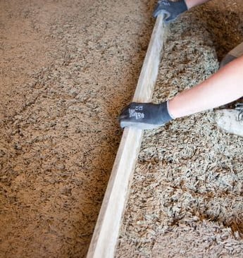 Réalisation d’une chape en béton de chanvre avec règle de nivellement manuelle