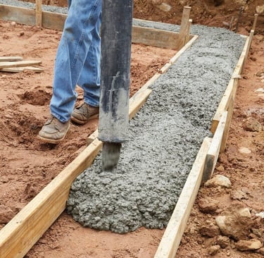 Coulage de béton dans un coffrage de fondation à l’aide d’un tuyau de pompage