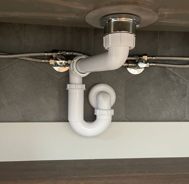 Installation d’un siphon sous évier avec raccordements flexibles pour l’arrivée d’eau