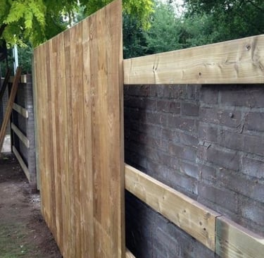 Pose de clôture en bois avec lames verticales sur structure en bois – assemblage en cours sur terrai