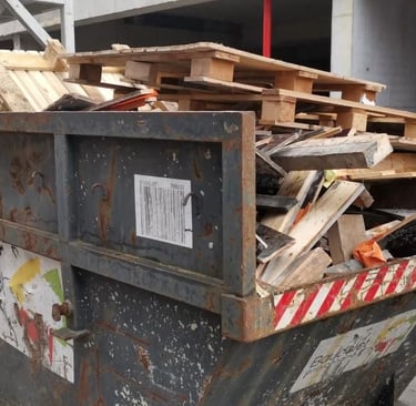 Benne de chantier remplie de bois et matériaux divers issus de travaux de démolition ou rénovation.