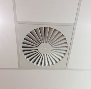 Grille de ventilation naturelle ronde intégrée au plafond, assurant un renouvellement d’air naturel.