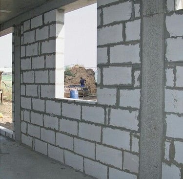Mur porteur en blocs de béton cellulaire avec ouvertures pour fenêtres, en cours de construction dan