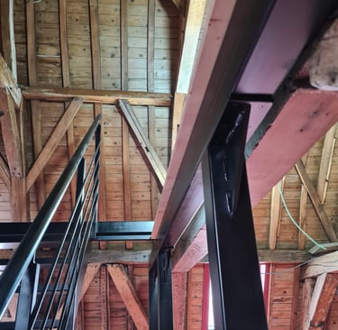Structure métallique en I installée sous charpente bois pour création de plancher porteur ou mezzani