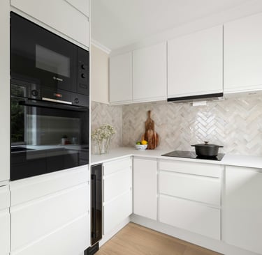 Cuisine blanche contemporaine avec crédence en chevrons et électroménager intégré