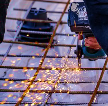 Découpe de barres d’armature métallique avec une meuleuse pour le ferraillage d’une dalle en béton