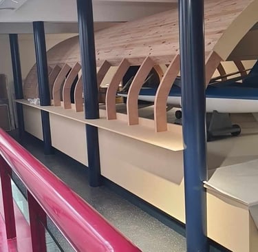 Structure voûtée en bois courbé intégrée à un aménagement intérieur avec poteaux métalliques – réali