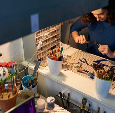 Fabricante de joyas que utiliza alicates para crear accesorios de cuentas hechos a mano