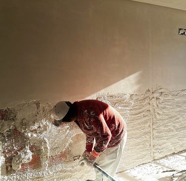 Aplicación de yeso proyectado en pared interior con máquina