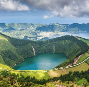 A picture of the top of a volcano with a road and fields around it.