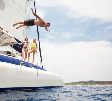 a man jumping off a boat in the ocean