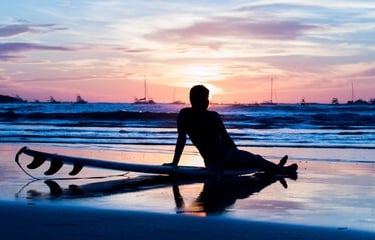 a person sitting on a surfboard in the water