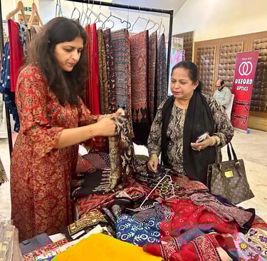 a woman standing in front of a table with a bunch of clothes