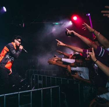 a man in a jacket and sunglasses on stage