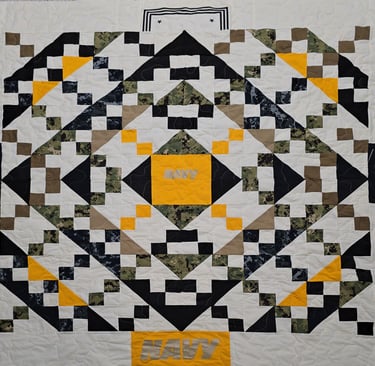 Military uniform memory quilt featuring service patches and uniform pieces arranged into a keepsake 