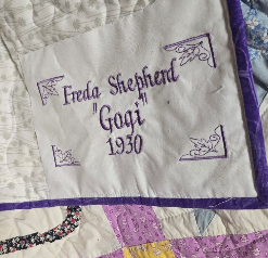 Embroidered label sewn into a memory quilt showing a name and birth date
