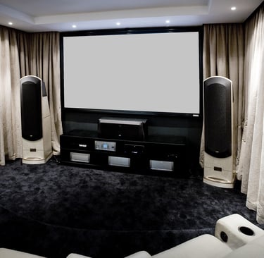 High-end home cinema with a large custom projection screen, plush seating, and premium sound system.