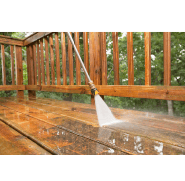 Power washing a wooden deck to remove dirt and buildup during an exterior cleaning service 