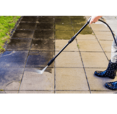 Pressure washing dirty concrete patio tiles to remove grime and restore a clean surface 