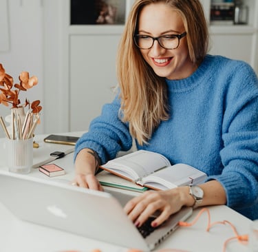 a woman sitting at a table with a book and a book
