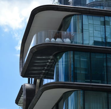 edificio moderno, lineas curvas, balcones con barandas vidrio, ventanales esquinas redondeadas