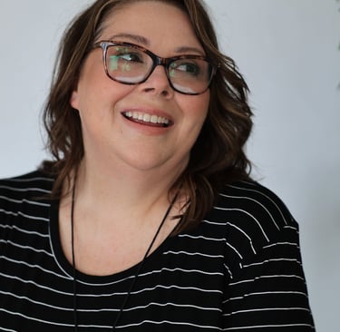 a woman with glasses and a necklace with a blue necklace