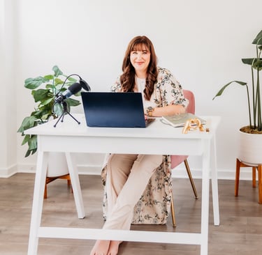 a woman sitting at a desk with a laptop computer